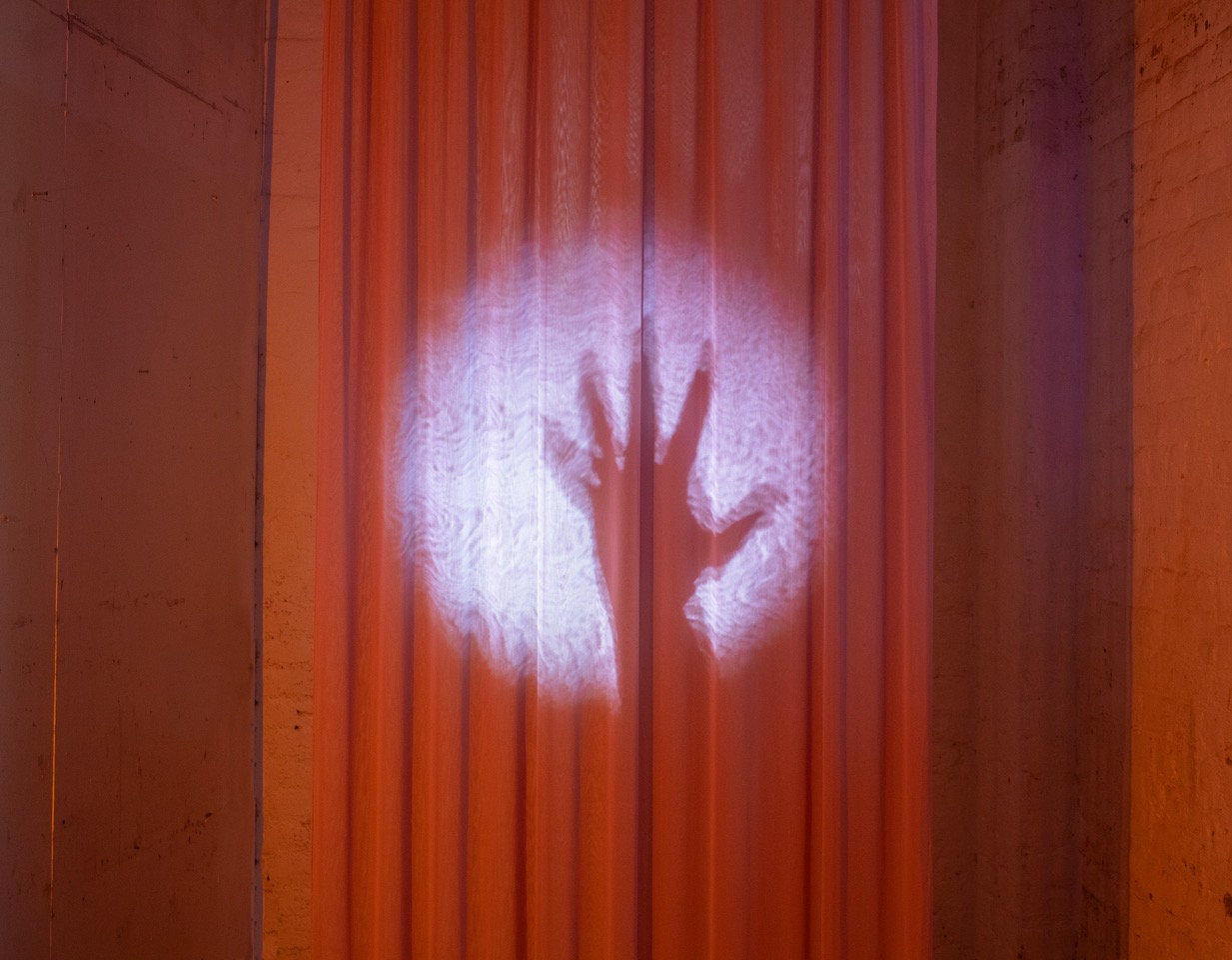 So Who Cares, So What?, installation, pink gauze, projection, yellow light, 14:37 mins, at Bow Arts Trust 2025, Courtesy of the artist.